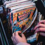 a photo of someone flipping through a bin of comics